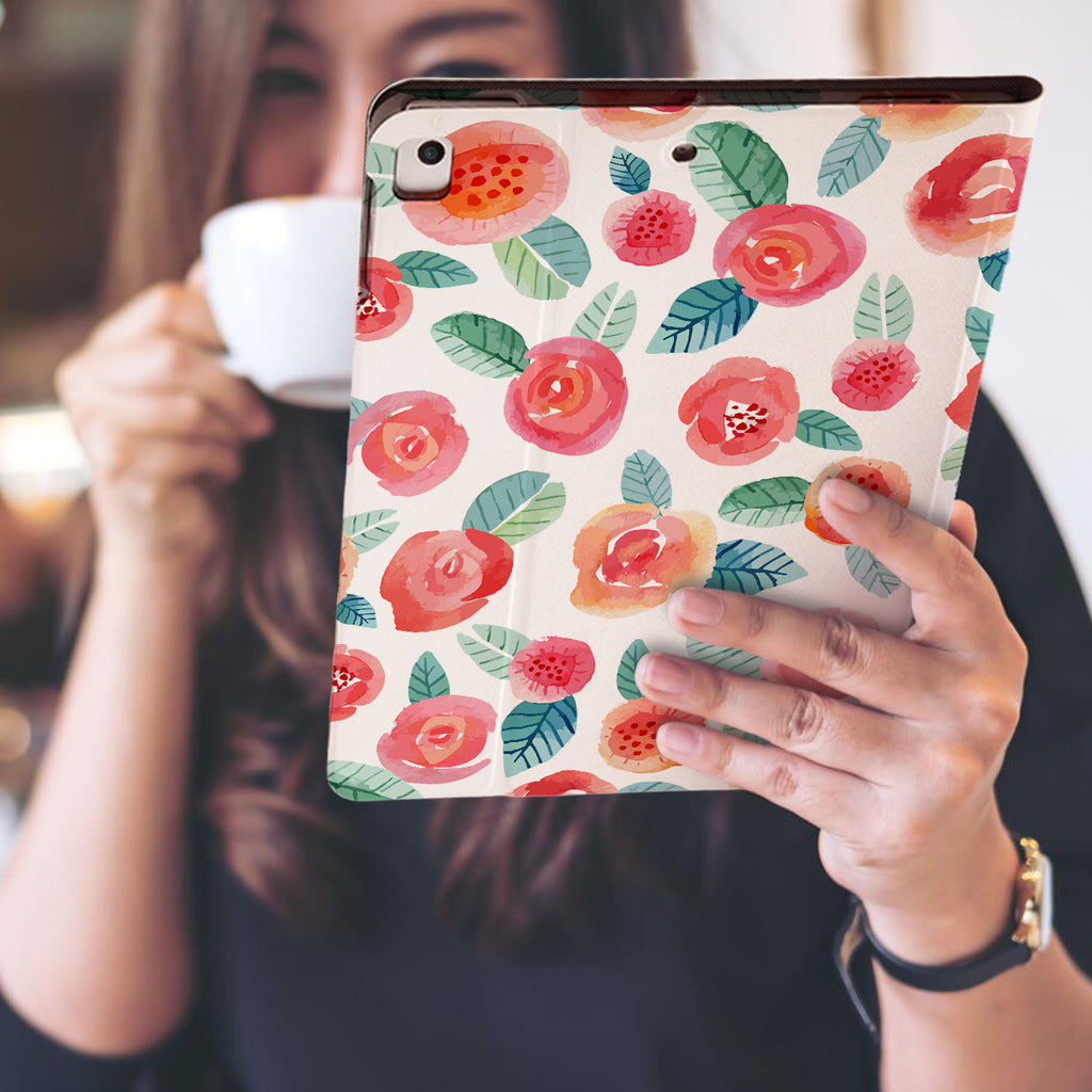 a girl is holding and viewing personalized iPad folio case with Rose design