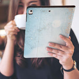 a girl is holding and viewing personalized iPad folio case with Marble Gold design