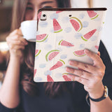 a girl is holding and viewing personalized iPad folio case with Fruit Red design