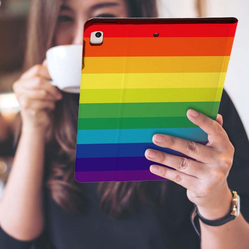 a girl is holding and viewing personalized iPad folio case with Rainbow design