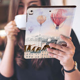 a girl is holding and viewing personalized iPad folio case with Travel design 